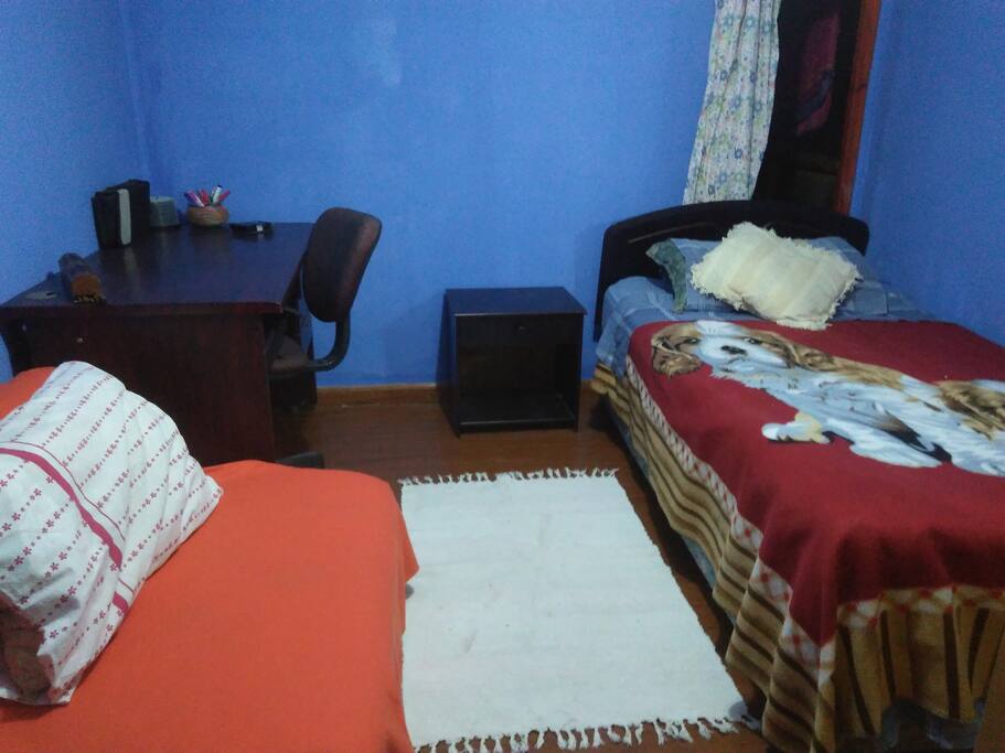 Dormitorio con cama de plaza y media, un sillón cama, escritorio, closet