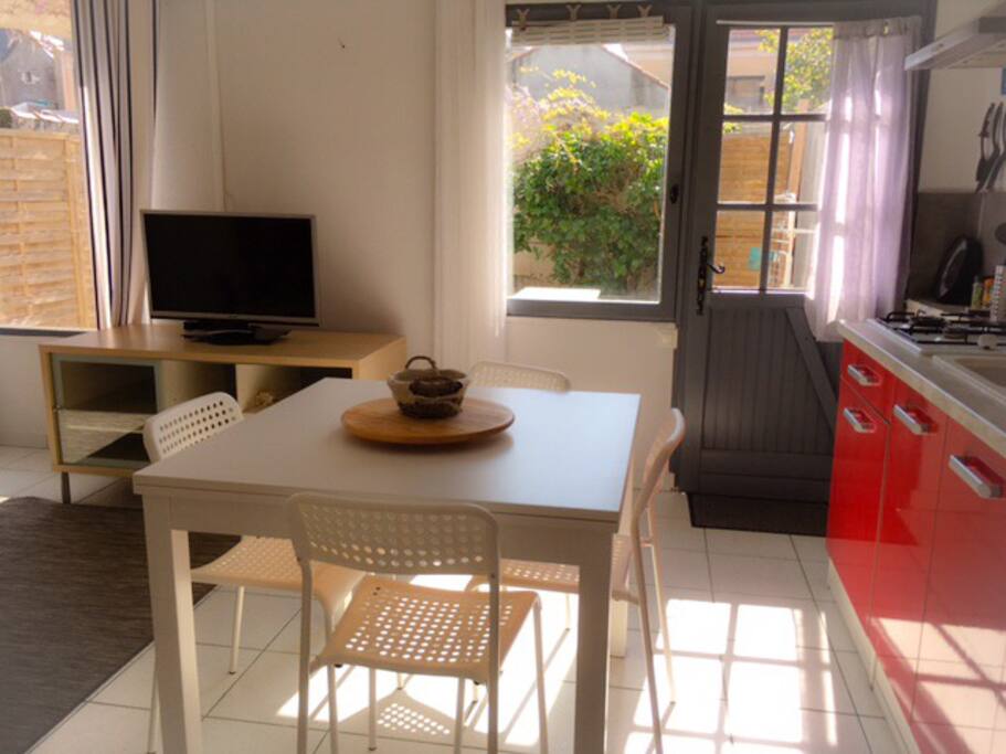 La pièce de vie (partie cuisine/ salle à manger) avec vue et accès sur le jardinet privatif (entièrement clos)
