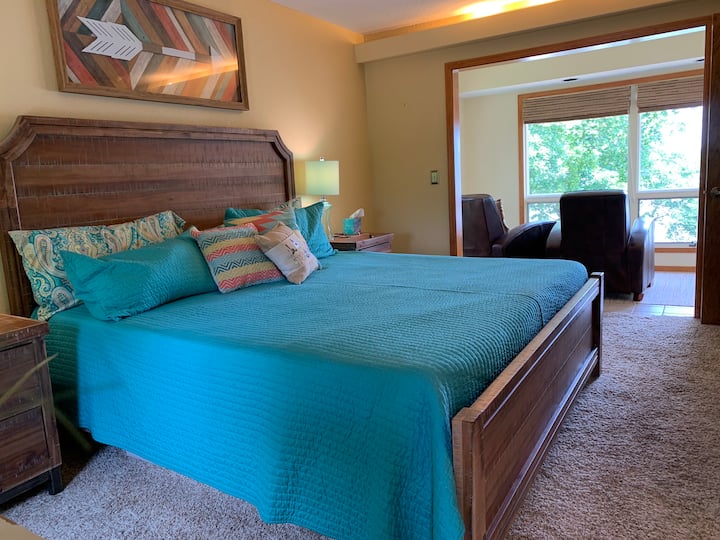 Chambre principale à l'étage avec coin salon donnant sur le lac.  Il y a 2 chaises inclinables et un bureau avec une imprimante si un espace bureau est nécessaire.  