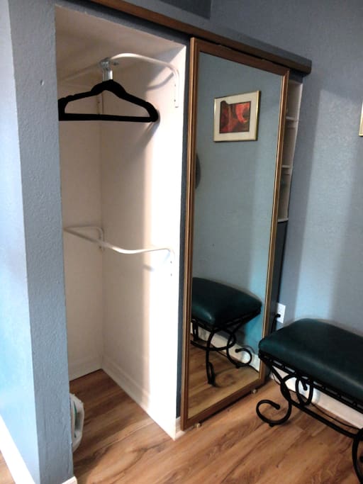 The closet contains 10 hangers, an iron and a tabletop ironing board.