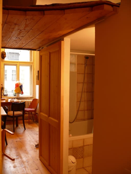 in the background: kitchen, on the right: bathroom