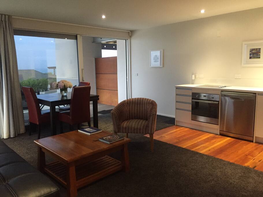 Open plan room includes dining table and lounge seating area with full kitchen facilities