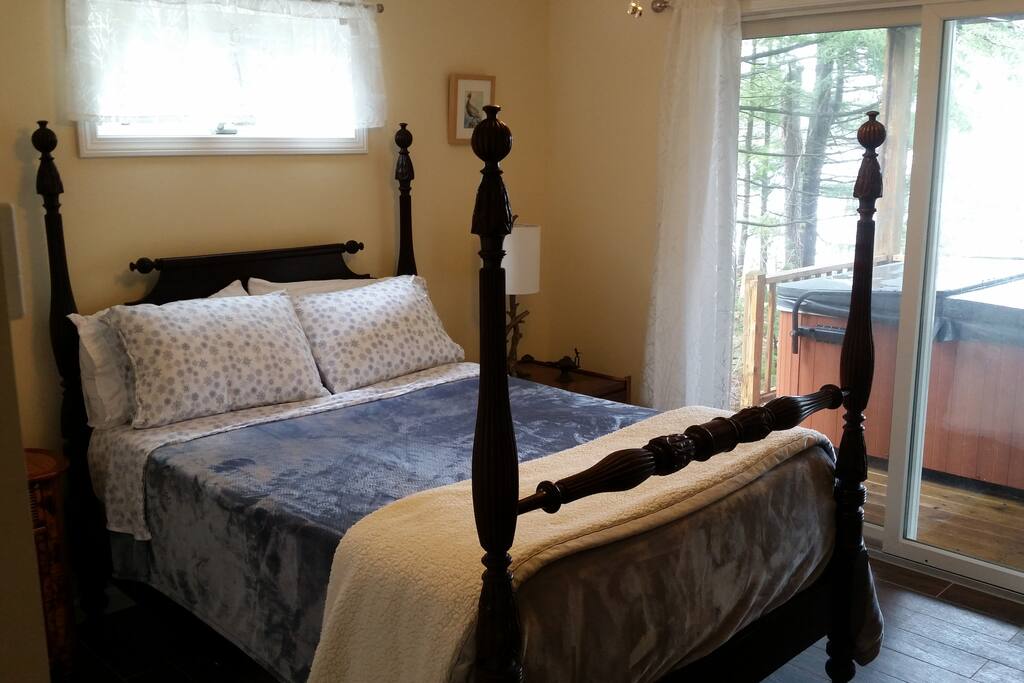Bedroom with sliders to the hot tub, deck, and lake