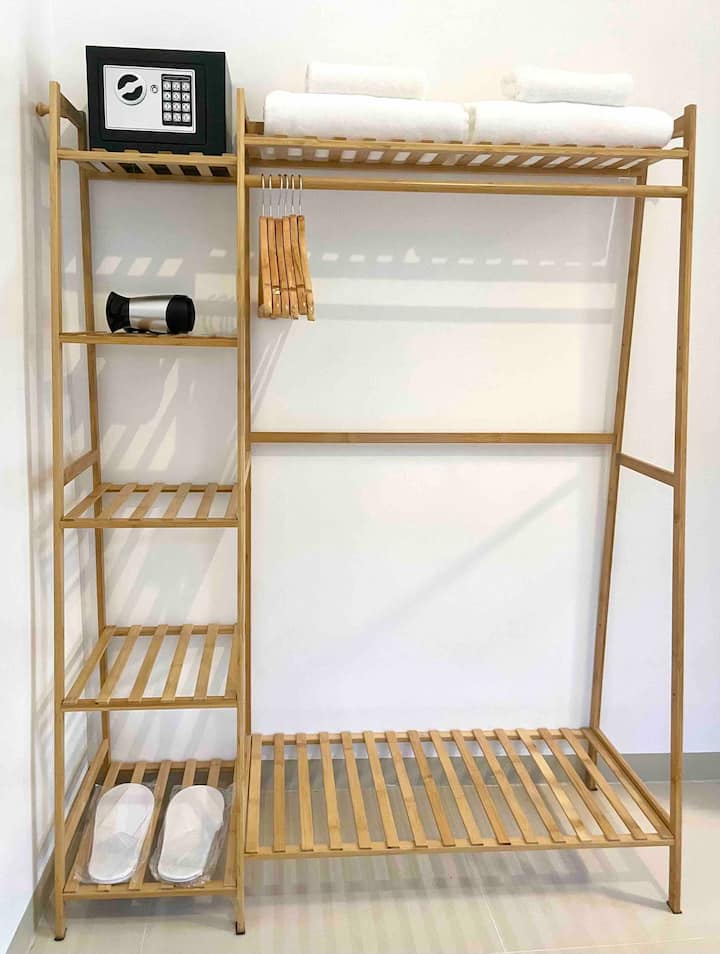 Armoire ouverte avec coffre-fort, cintres, serviettes et sèche-cheveux