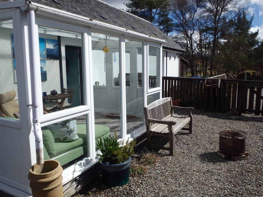 Back of the cottage with conservatory leading through to living space. Outdoor fire pit