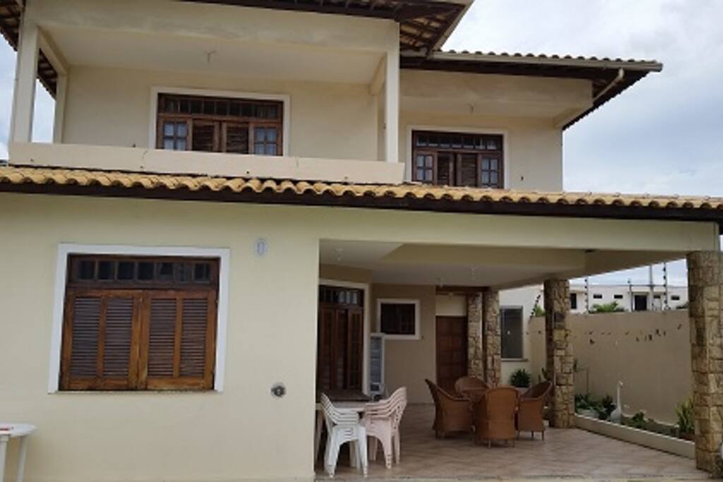 Parte de trás da casa com varanda e acesso à piscina