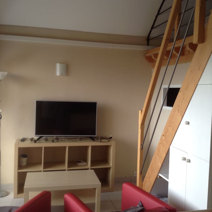 télé et escalier menant à 2 chambres en mezzanine
