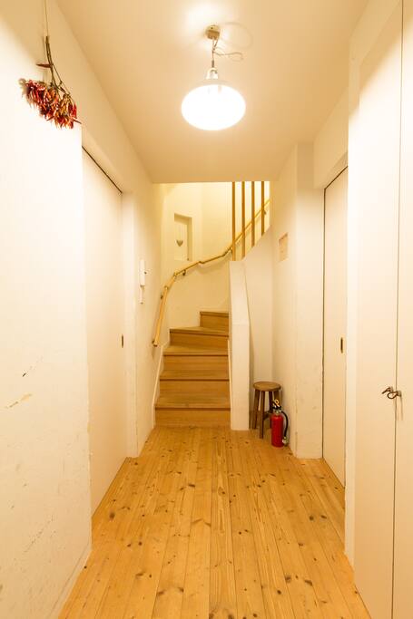 入ってすぐの廊下になります。階段手前の右側が2名様用のお部屋、左側が1名様用のお部屋になります。3名様の場合は両方の部屋を使って頂きます。/This is the 1st floor. The room for two is on the right side, the room for one is left side. If you book for three, you can use both rooms.