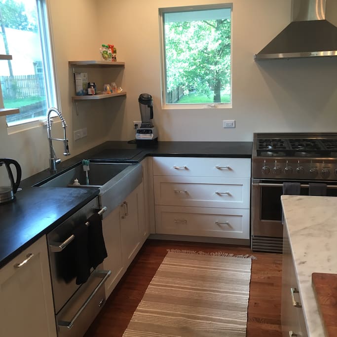 DCS double-tier dishwasher, DCS chef's six-burner professional range, and Kohler two-bin sink with apron-style front. Lovely views of backyard.
