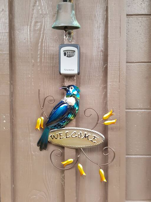 The lockbox located to the right of the front door between the bell and Welcome Tui.