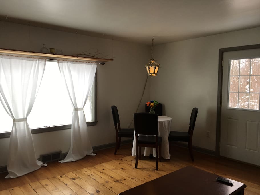 The living room space with lots of natural light. There is a fire exit door- soon to be leading to a new outside deck and a view of Lake Superior.