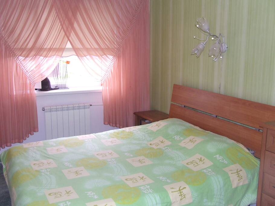 Master bedroom with a large double bed and a closet with a mirror.