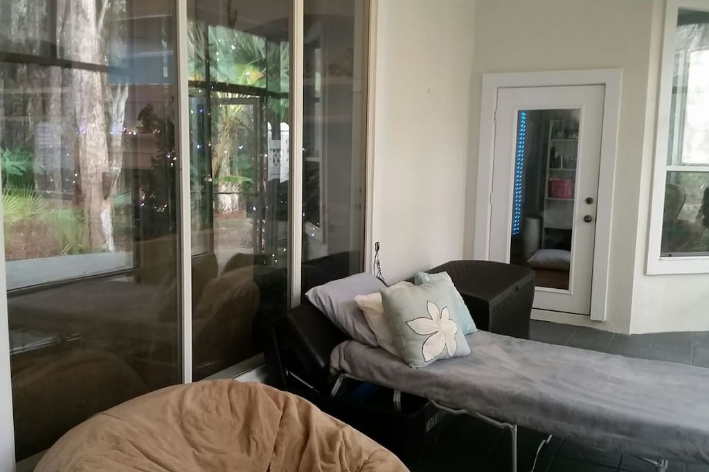 View of Florida room with ottoman pulled out. Windows shown are to the living room of the home.