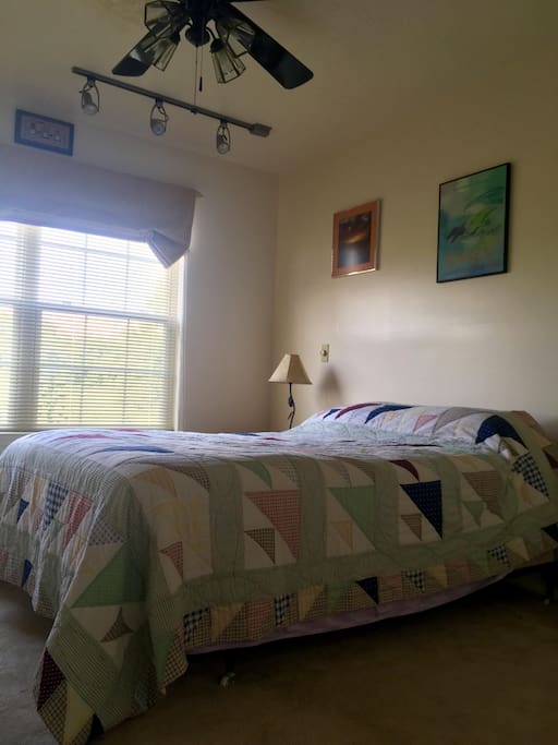There's a sunny window in the bedroom, along with a ceiling fan.