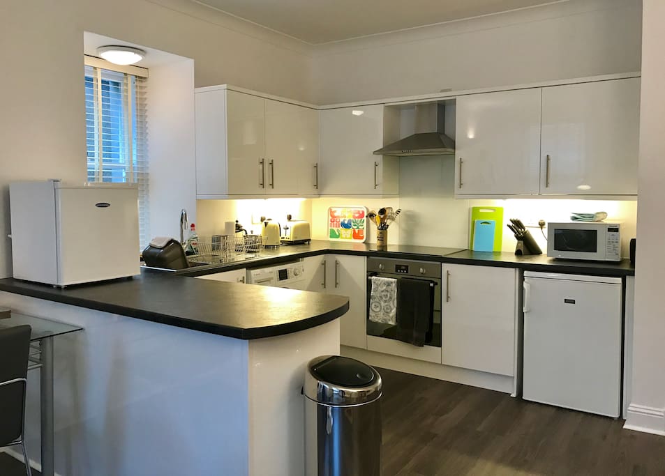 Kitchen with washer/drier, fridge, microwave & small freezer.