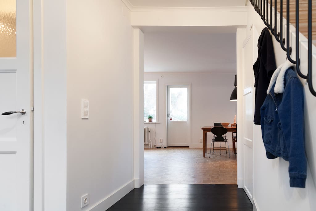 Hallway looking through the house into kitchen and living room. Door leading out to veranda.