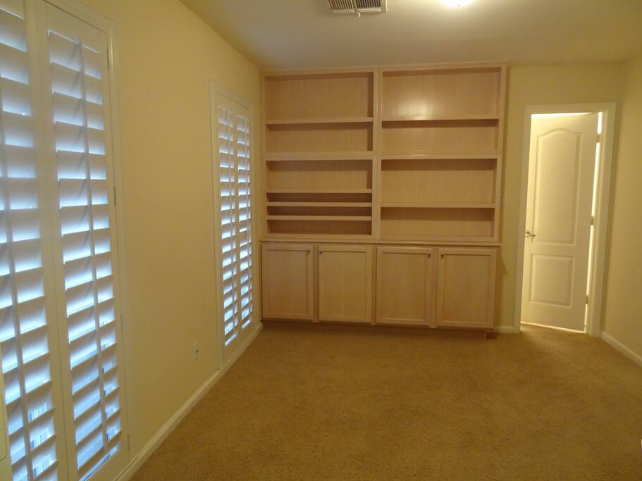 2nd bedroom with built-in bookcase, shelving, cabinets