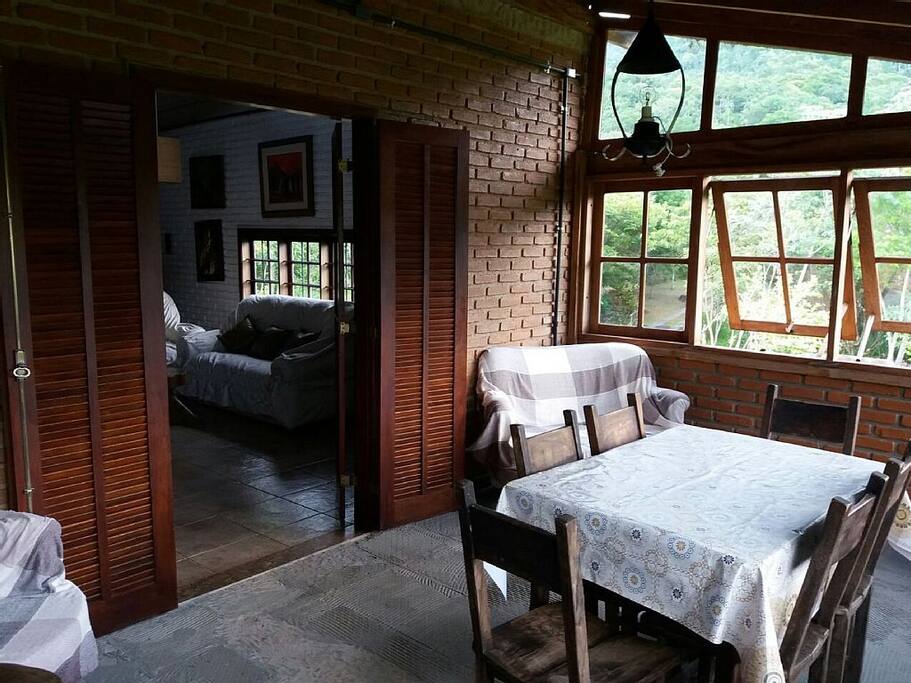 Varanda fechada com mesa, poltronas