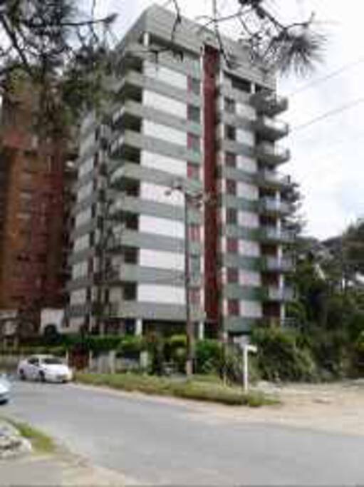 El edificio . Estacionamiento al lado del mismo . Descubierto medía sombra