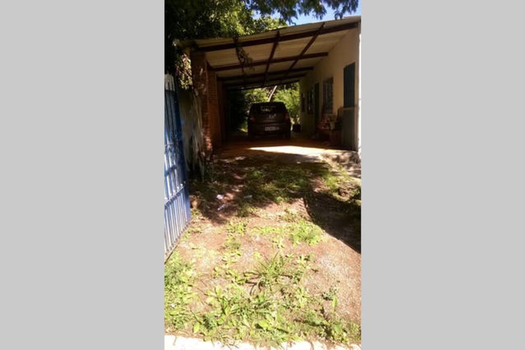entrada da casa com garagem e área coberta para até 3 carros