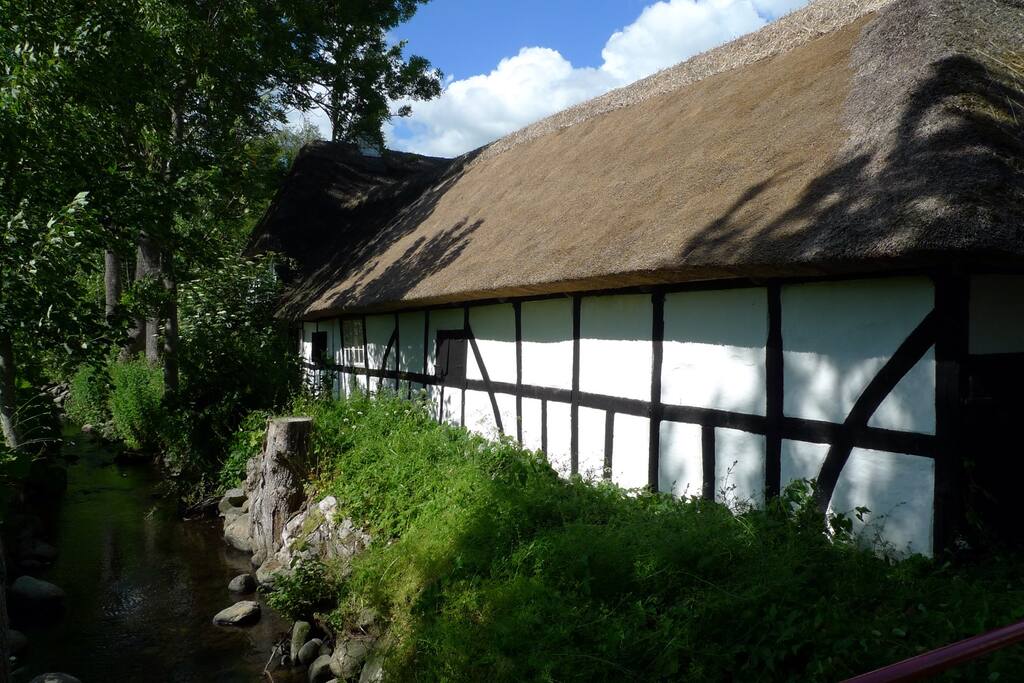 En lille å løber langs gården.