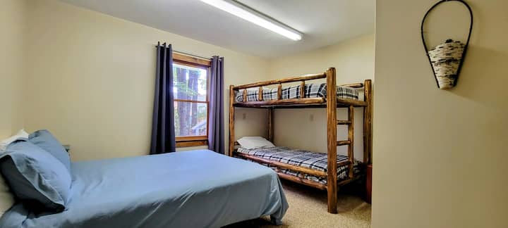 The lower floor bedroom 5 features one (1) QUEEN size bed, a twin bunk bed, and a chair.