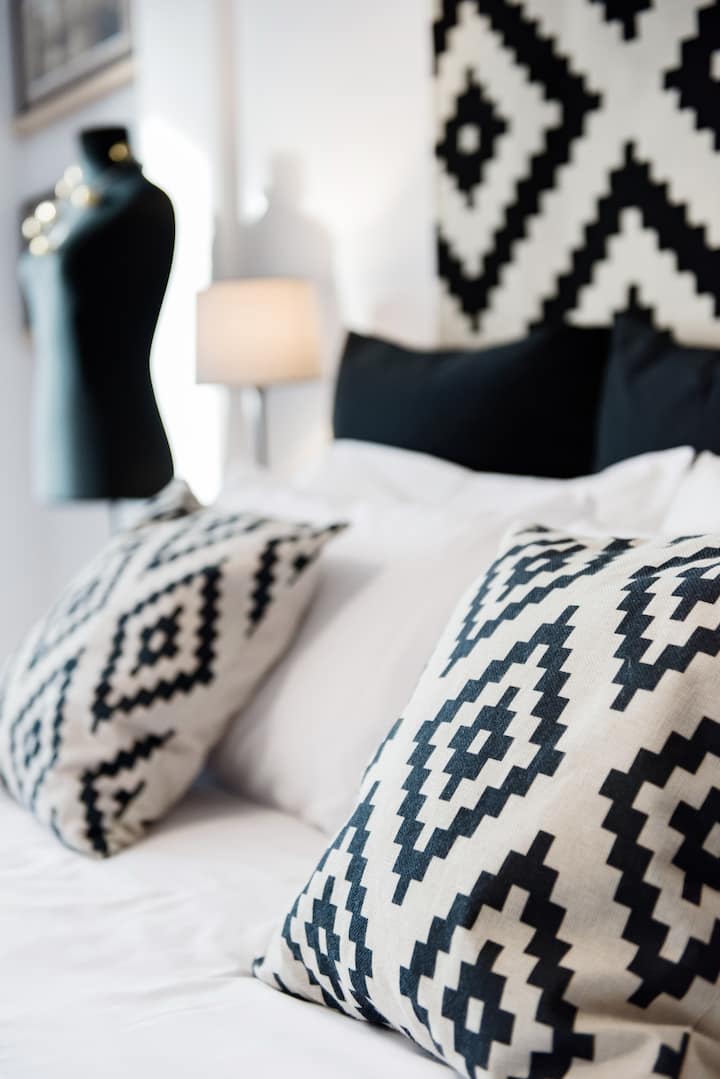 Black and white printed fabrics give a fresh touch to the bedroom.