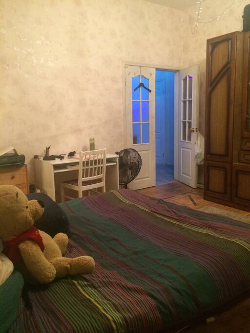 Entrance , desk, and a double size bed.