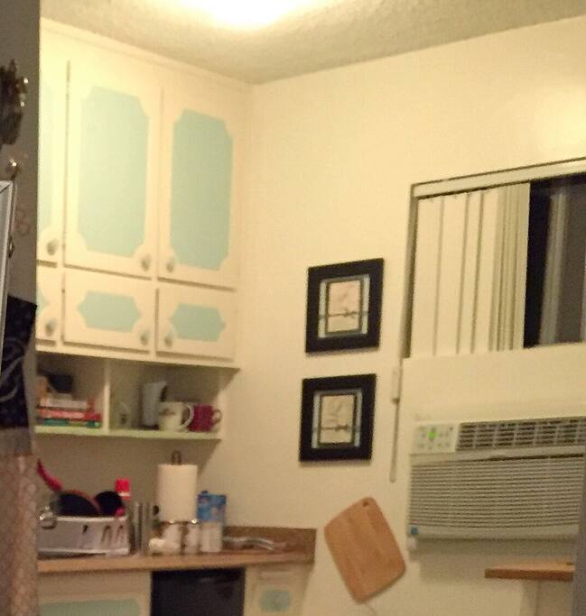 There is a mini fridge next to the sink, oven/stove, and toaster