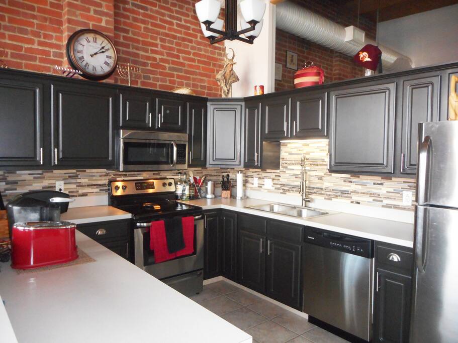 Large open kitchen with new stainless steel appliances.