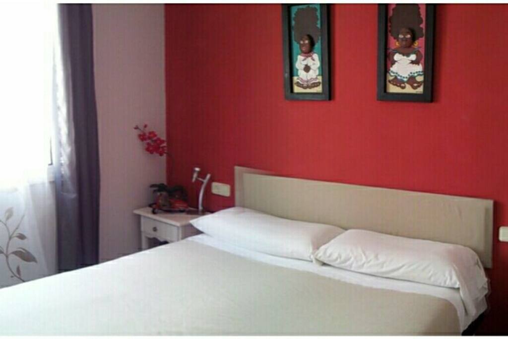 Habitación con cama de matrimonio, escritorio, TV dvd y perchero.