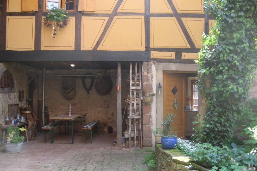 Arrière cour donnant sur l'ancienne écurie à gauche de l'entrée du gîte avec bois de chauffage (côté nord)