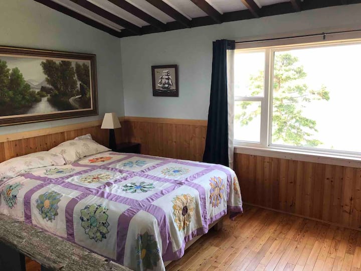 The upstairs bedroom with a queen size bed , half bath and a lovely ocean view.