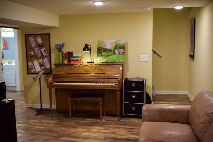 Piano and stairway upstairs. Please note there is not a formal door between the living room space to the upper level.