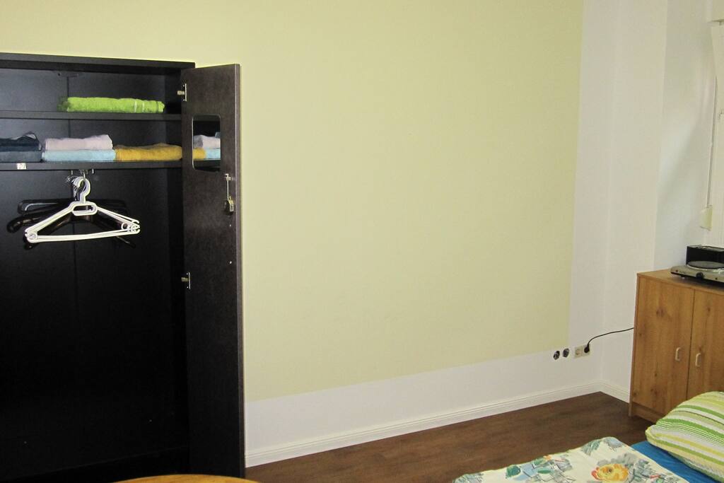 Schlafzimmer (Zi 2) mit Blick auf geöffneten Kleiderschrank mit Handtüchern inliegend