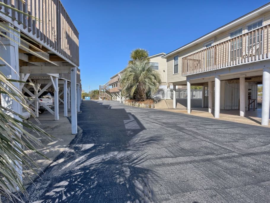 This view is from the entrance (the two-lane road and beach are behind the camera). Your unit is located in that back building on the right, bottom floor near the middle. Parking is available underneath.