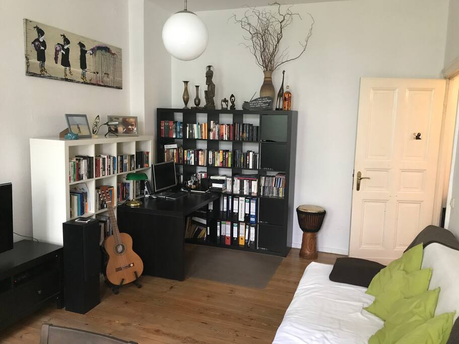 Wohnzimmer mit ausklappbarer Schlafcouch und Scheibtisch