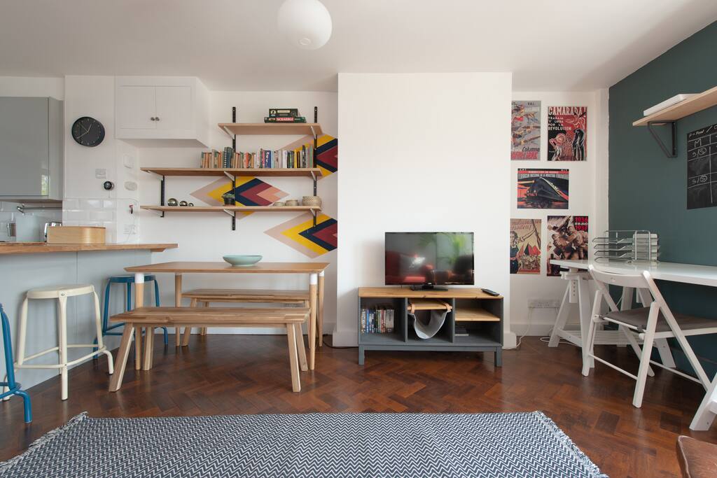there is a six person dining table with full cutlery and cooking equipment in the kitchen