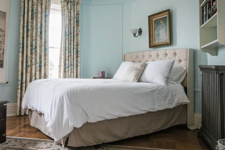 ห้องนอนสีฟ้าพร้อมผ้าม่านใหม่หัวเตียงเครื่องทำความร้อนแบบโบราณ