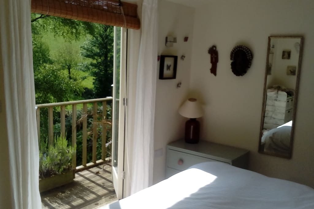 The luminous bedroom with doors that open onto the balcony.