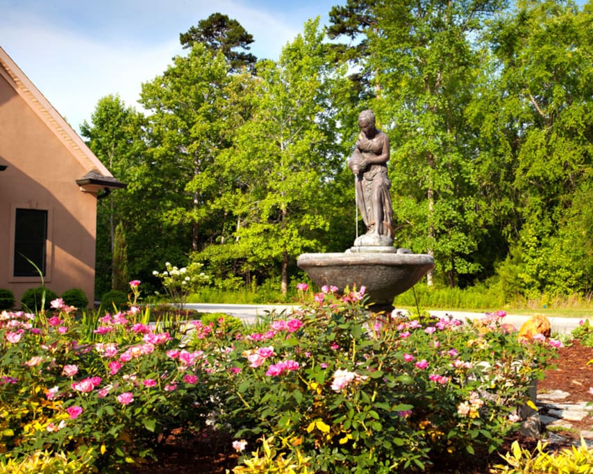 Lush landscaping, circular drive and decorative fountain adorn the front yard.
