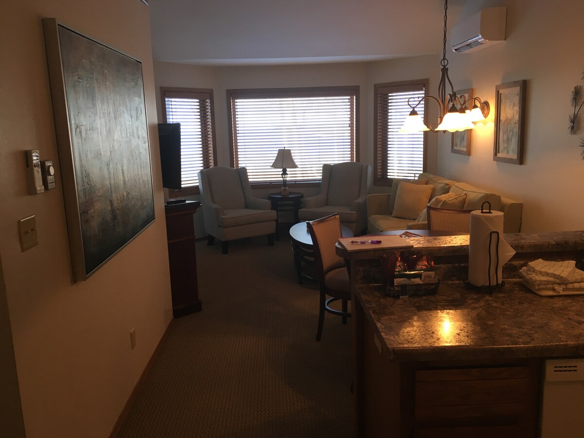 พื้นที่นั่งเล่นกว้างขวางที่นำไปสู่ระเบียงที่มองเห็นสระว่ายน้ำและทะเลสาบ