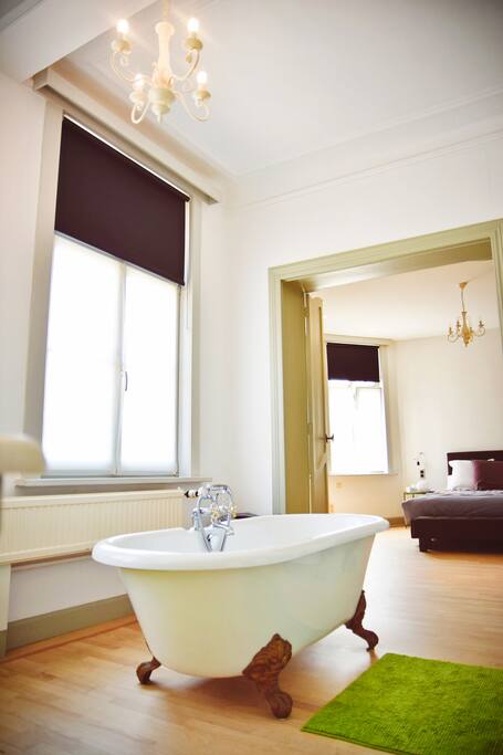 Zicht vanuit de badkamer naar de slaapkamer wanneer de dubbele deur openstaat