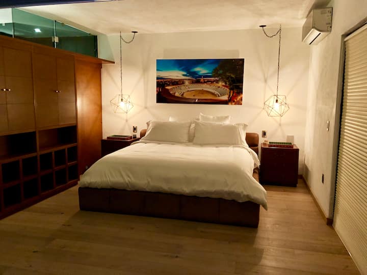 Esta cama te abrazará hasta que te duermas. La obra de arte es una fotografía del estadio de corridas de toros junto a la casa en el dormitorio principal.