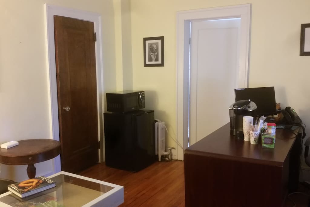 spare room with mini fridge, microwave, krups machine, iron & board