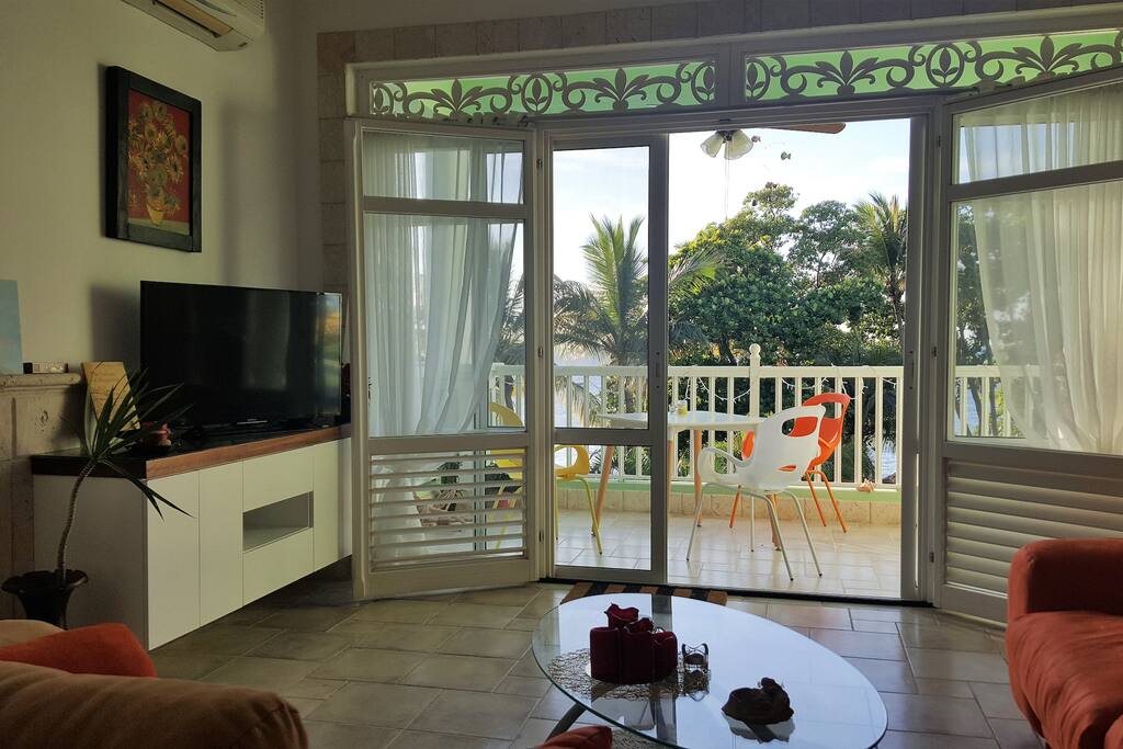 Cozy living room with large flat screen TV set with cable channels.