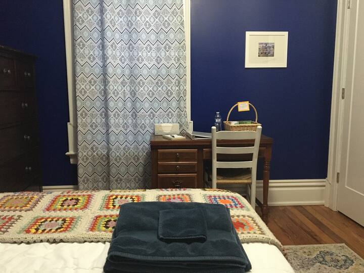 Bedroom has a desk and dresser with drawers available for use as well as a closet with plenty of hangers.