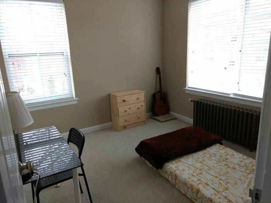 Well lit bedroom with closet space and drawers