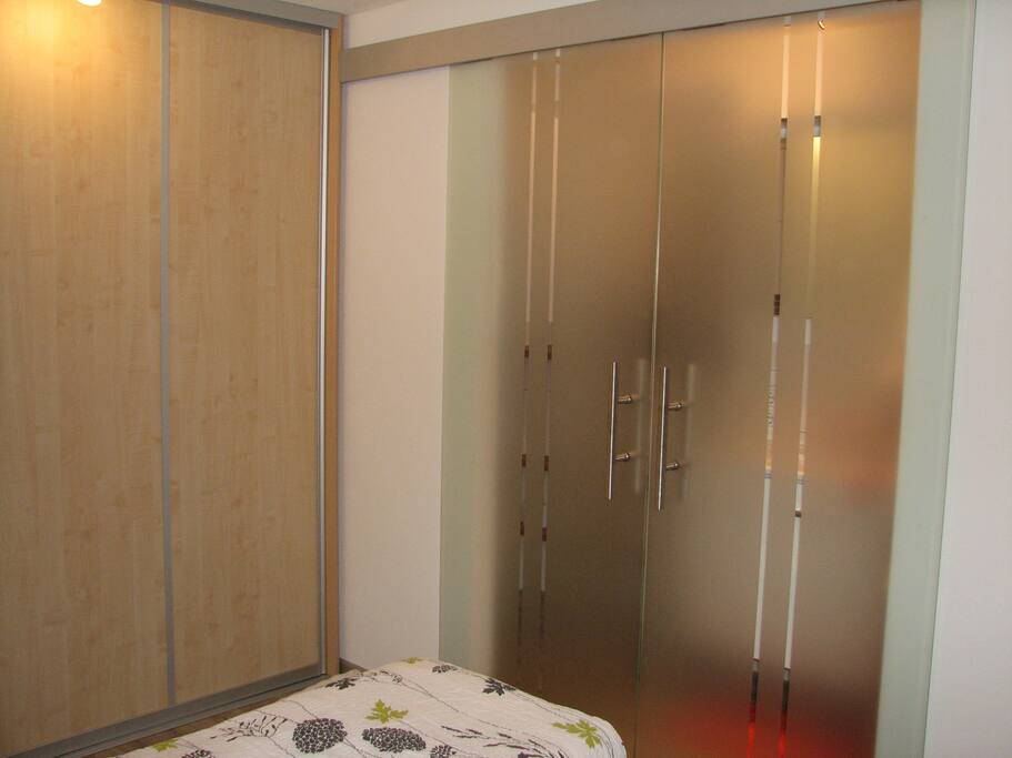 Schlafzimmer mit Einbauschrank. Schiebetür trennt das Bad ab.