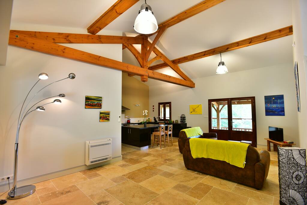 A large living room with 2 sofas and a TV opening on the terrace